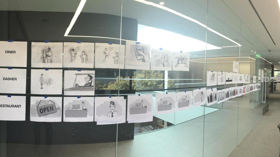 DoorDash storyboards arranged across a long mirrored office wall