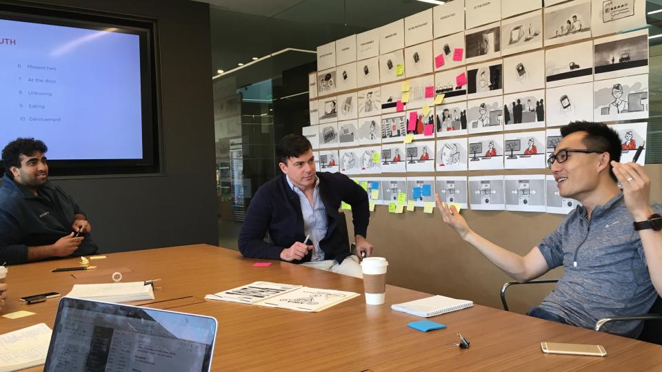 DoorDash team discussing a wall of experience storyboards