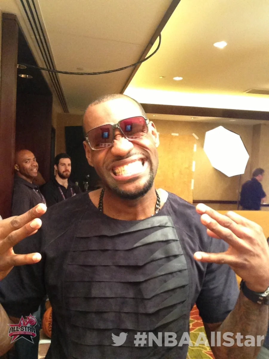 Smiling man posing with his hands raised at the Twitter Mirror during NBA All-Star Weekend.