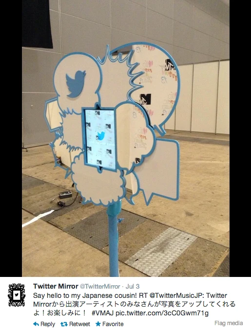 Twitter bird sculpture installed in an event space with a social post displayed beneath it.